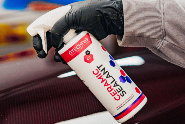 Individual spraying Gtechniq ceramic sealant solution on a car.