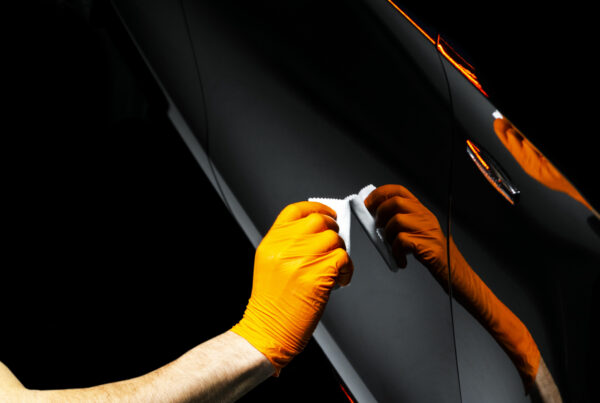 Car polish wax worker hands polishing car. Buffing and polishing vehicle with ceramic. Car detailing. Man holds a polisher in the hand and polishes the car with nano ceramic. Tools for polishing