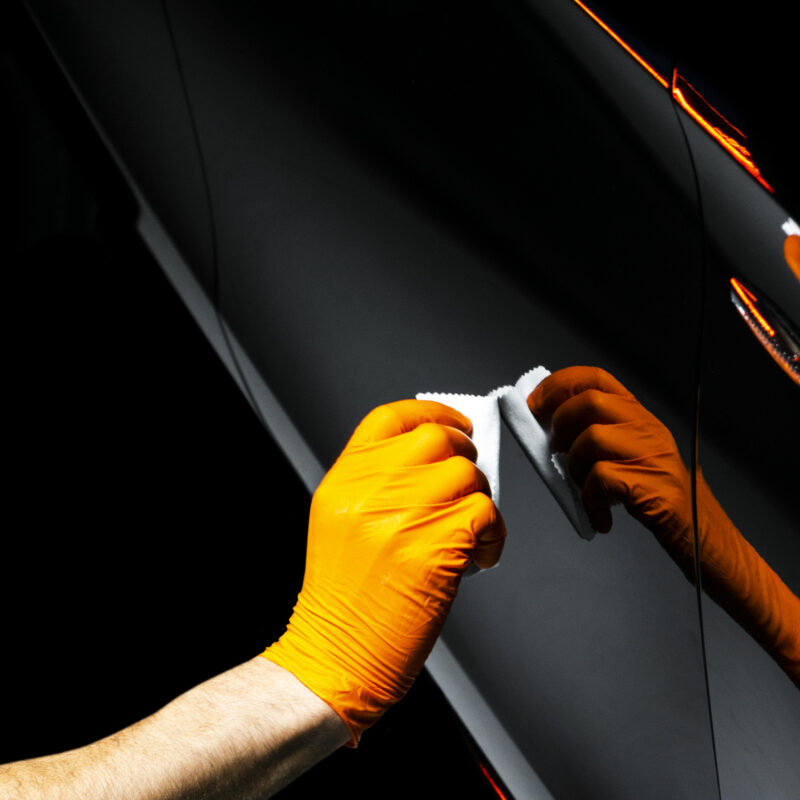 Car polish wax worker hands polishing car. Buffing and polishing vehicle with ceramic. Car detailing. Man holds a polisher in the hand and polishes the car with nano ceramic. Tools for polishing