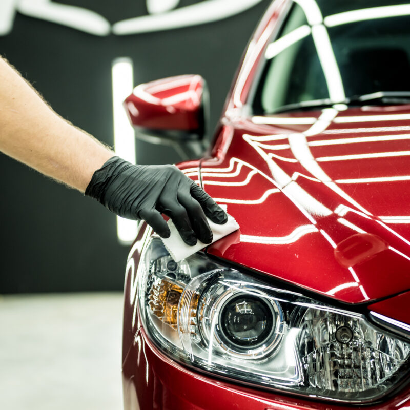Car service worker applying nano coating on a car detail